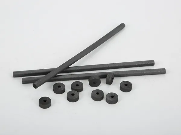 Algunos electrodos de disco de grafito y barras de grafito espectral se colocan en el escritorio.